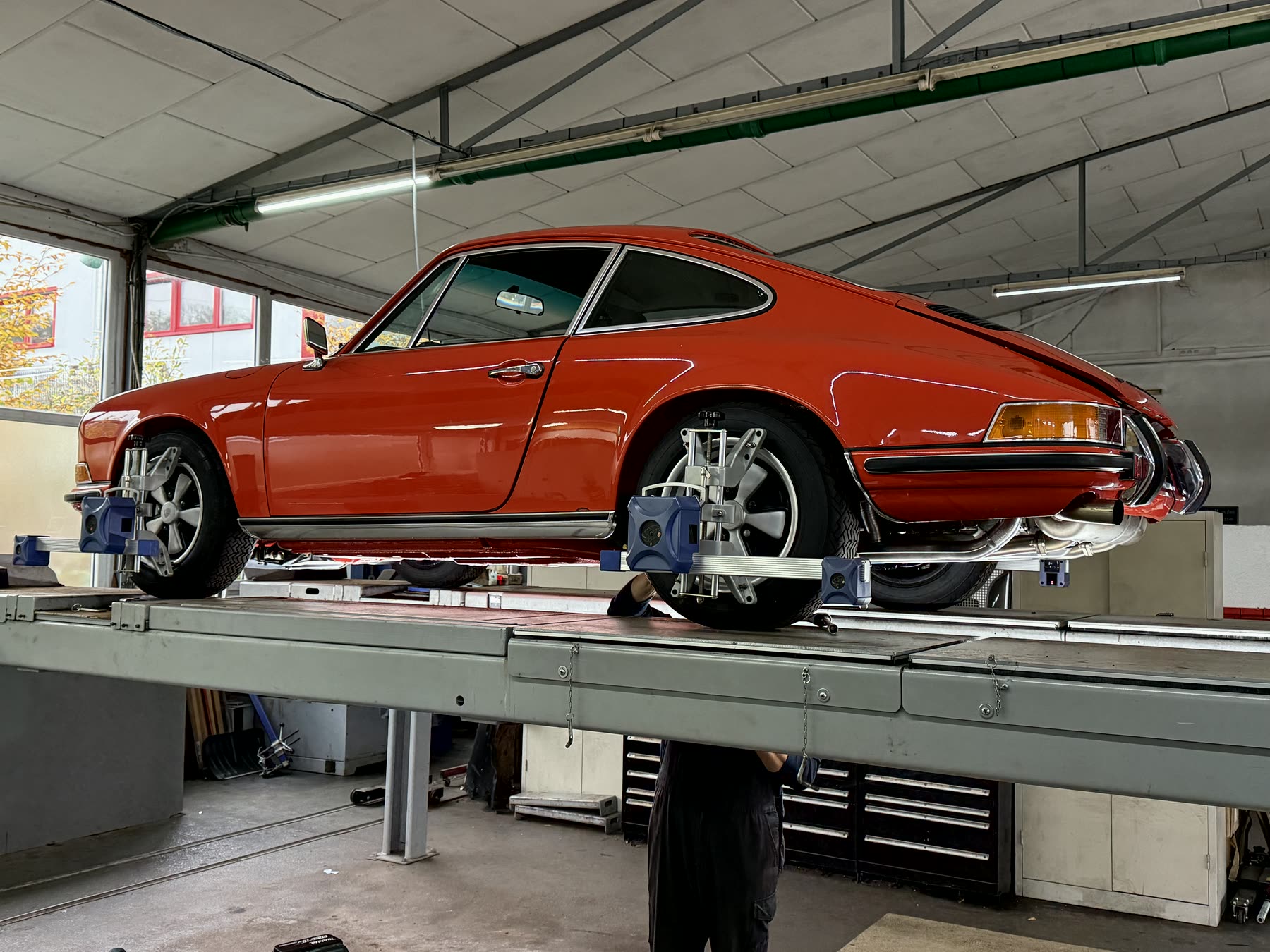 Porsche 911 orangerot auf der Bühne während der Restaurierung