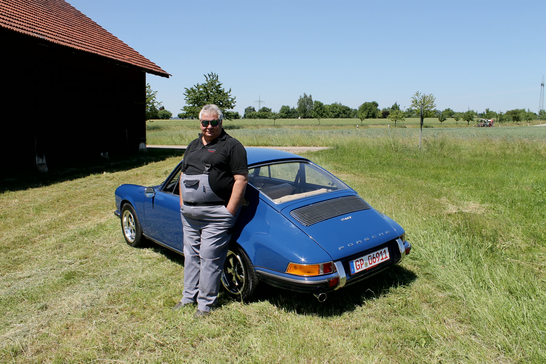 Peter Christoforidis an einem blauen Porsche 911